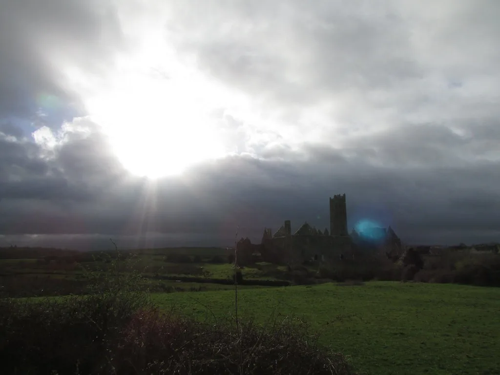 Quin Abbey silhouetted against the low sun.